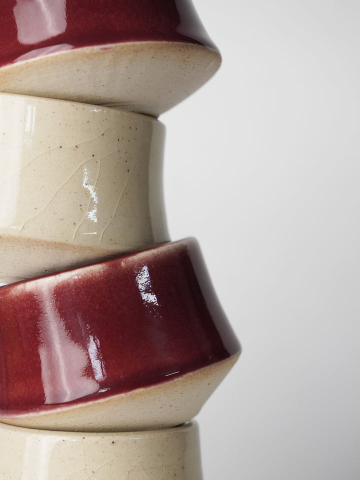 Macro detail of artisanal ceramic glaze showing the smooth satin matte and vibrant cherry red finish
