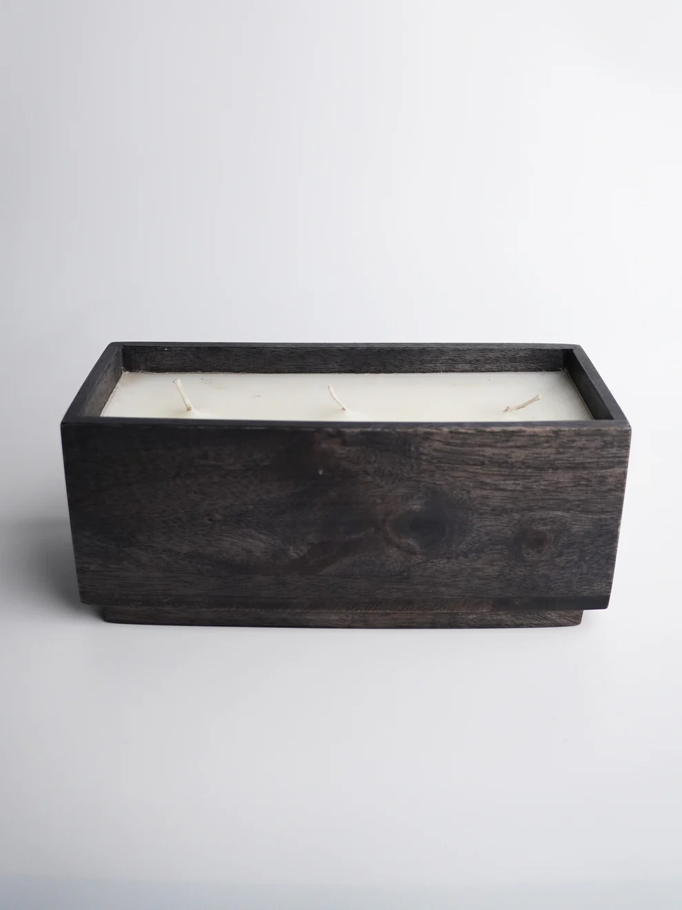 Minimalist dark mango wood candle holder with multiple wicks for modern home ambiance